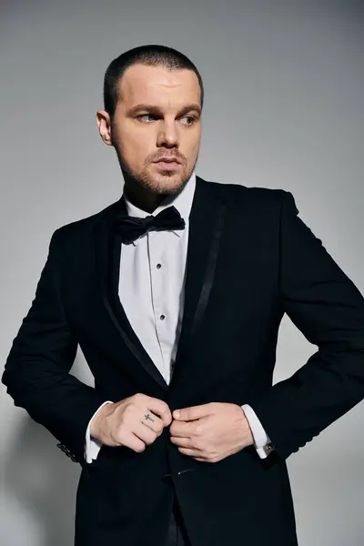 A stylish man adjusts his tuxedo, preparing for a special evening. — Stock Photo