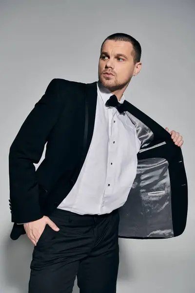 Un hombre con un traje negro ajusta su chaqueta, mostrando el forro. — Stock Photo