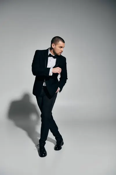 A stylish man in a tuxedo stands with a confident and relaxed pose. — Stock Photo