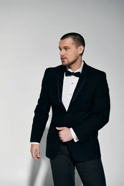 A man in a tuxedo stands confidently, his gaze directed off-camera. — Stock Photo