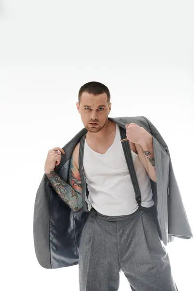 Confident man with tattoos and suspenders stands with style and rebellion. — Stock Photo