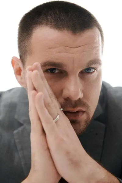 Man with stylish haircut, ring, chin on hands, looks thoughtful. — Stock Photo