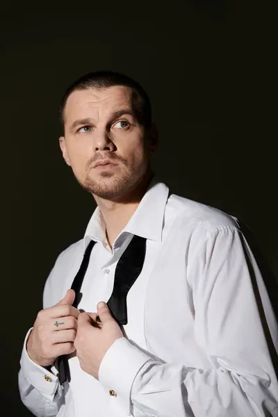 Чоловік налаштовує свою пов'язку, виключаючи впевненість і стиль. — Stock Photo