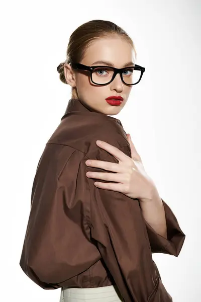 Una giovane donna con labbra rosse audaci e occhiali alla moda guarda oltre le spalle. — Foto stock