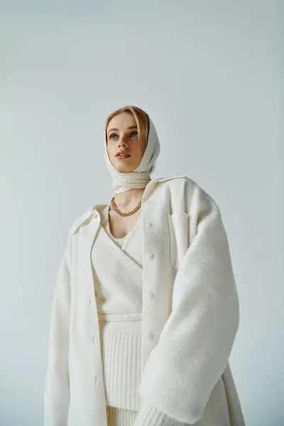 Young woman in white outfit, lost in thought, looks up. — Stock Photo