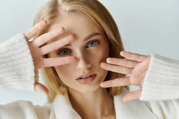 A woman in white partially hides her face, leaving a hint of mystery. — Stock Photo