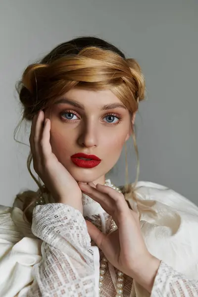 The young woman wears a white lace blouse with a braided crown and pearl jewelry. — Stock Photo