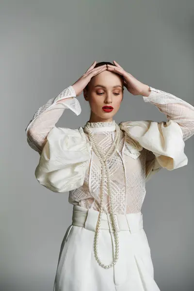 A woman in white with a pearl necklace and a soft, contemplative expression. — Stock Photo