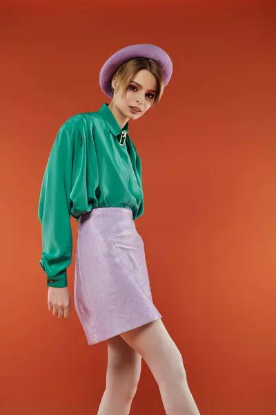 A woman in a green shirt and purple skirt stands confidently in a studio setting. — Stock Photo