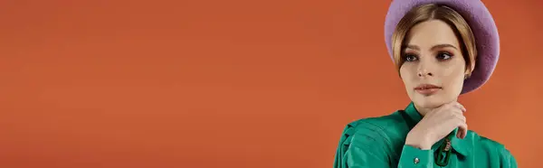 A woman with a stylish, grungy look poses against a vibrant orange background. — Stock Photo