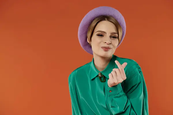 A woman with a stylish grunge look makes a heart sign with her hand. — Stock Photo