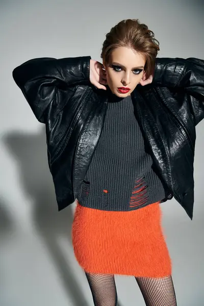 A woman in stylish outfit poses confidently against light background. — Stock Photo
