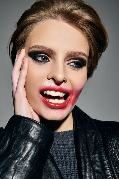 A woman with bold makeup and a leather jacket poses with a playful expression. — Stock Photo