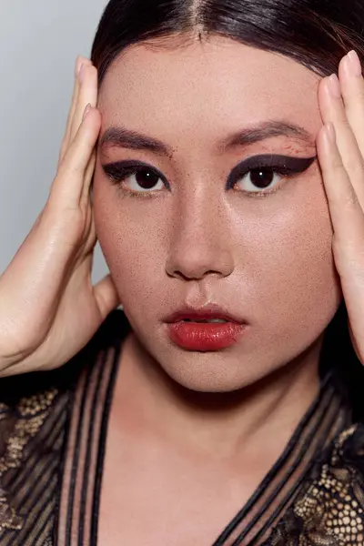 A close-up of a beautiful Asian woman, her eyes captivating with bold eyeliner. — Stock Photo