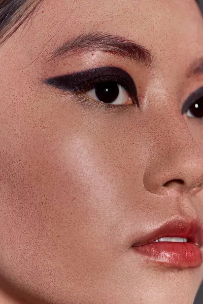 A woman's eye and lip with bold makeup. — Stock Photo