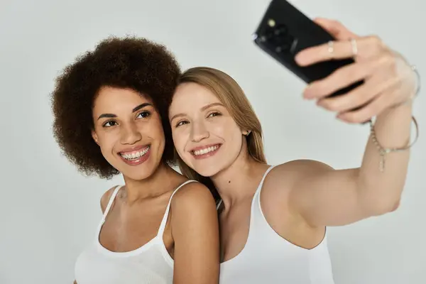 Two women wearing tank tops pose for a selfie. — Stock Photo