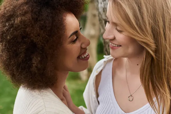 Two women, gaze lovingly at each other, celebrating their growing family. — Stock Photo