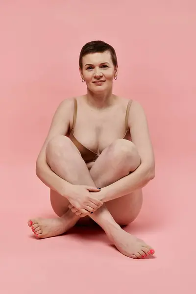 A woman with short hair sits with her legs crossed — Stock Photo