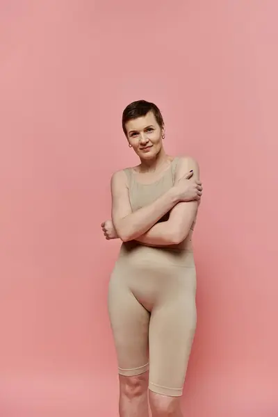 A woman with short hair stands in a bra, looking directly at the camera. — Stock Photo
