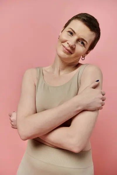 A woman with short hair wearing a bra smiles gently at the camera, conveying support for breast cancer awareness. — Stock Photo