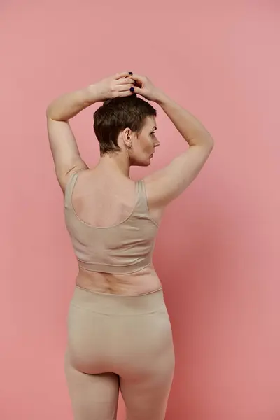 A woman with short hair wearing a pink ribbon bra, supporting breast cancer prevention. — Stock Photo