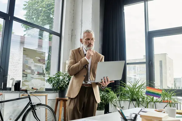 A middle-aged, bearded man in a suit teaches online, looking thoughtfully at his laptop. — Stock Photo