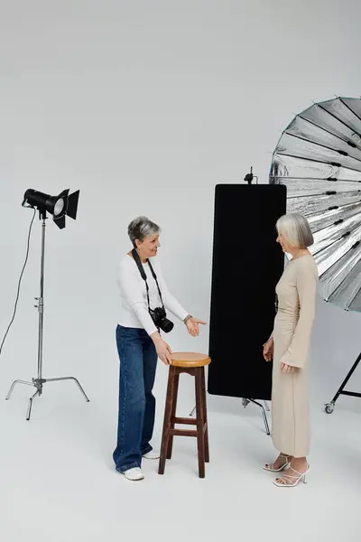 Two women, a photographer and a model, pose in a photo studio. — Stock Photo