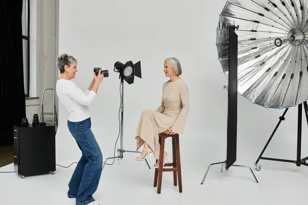 A photographer captures a portrait of her partner in a studio setting. — Stock Photo