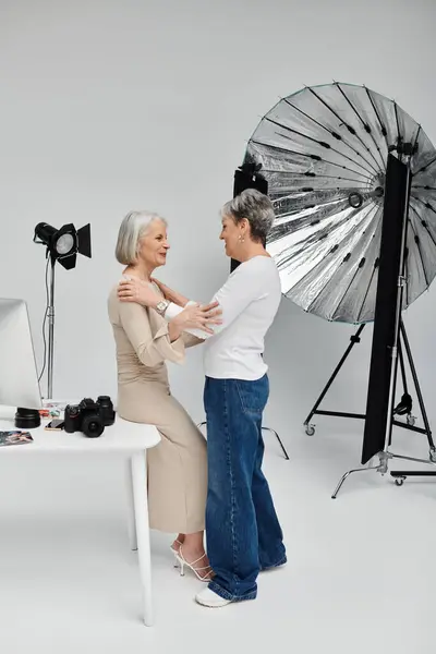 A lesbian couple enjoys a photoshoot in a studio, their love evident as they share a tender moment. — Stock Photo