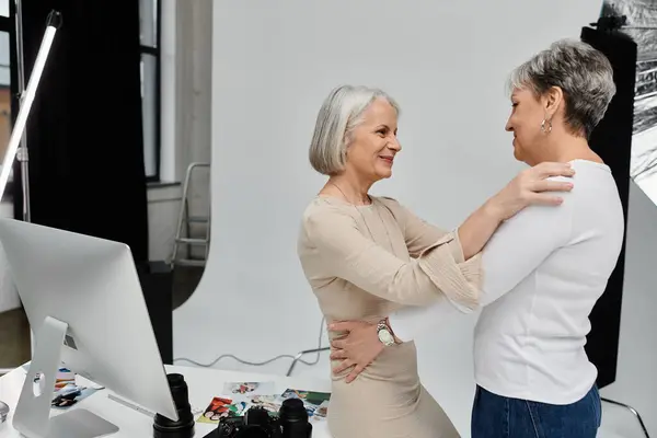 Duas mulheres maduras estão perto, uma atrás da outra, abraçando em um estúdio de fotos. — Fotografia de Stock