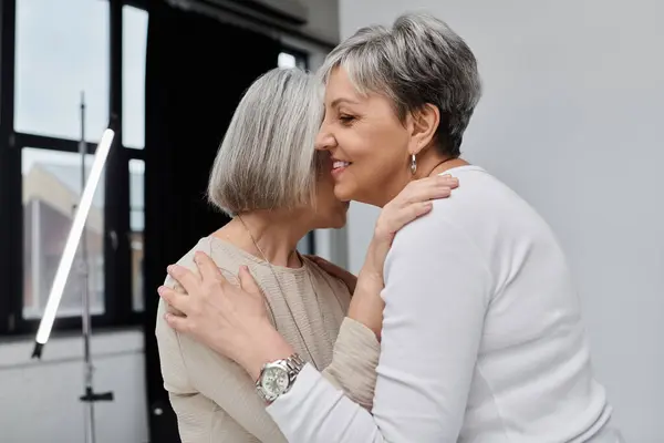 A couple shares a tender embrace during a photoshoot in a studio setting. — Stock Photo