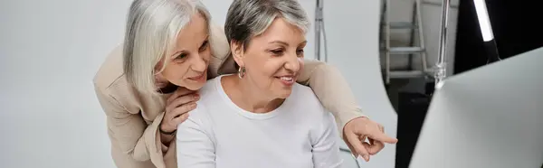 Dos mujeres, parejas, revisan fotografías juntas durante una sesión de fotos de estudio. — Stock Photo