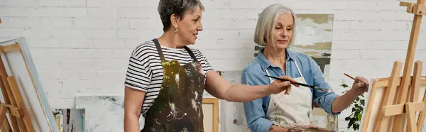 Two women in an art studio, painting and learning new skills together. — Stock Photo