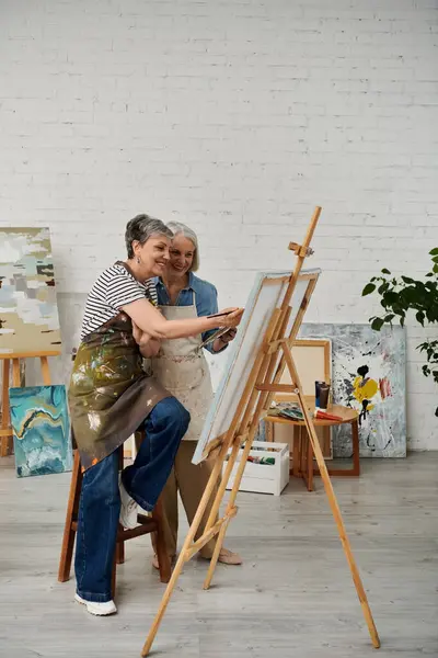 Two women paint together in an art studio. — Stock Photo