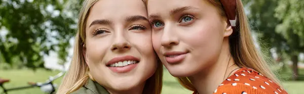 Two women, a young lesbian couple, stand close together in a park, enjoying a moment of intimacy and affection. — Stock Photo