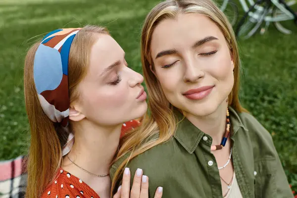 Ein junges lesbisches Paar teilt einen zarten Moment in einem grünen Park und genießt ein romantisches Date. — Stockfoto