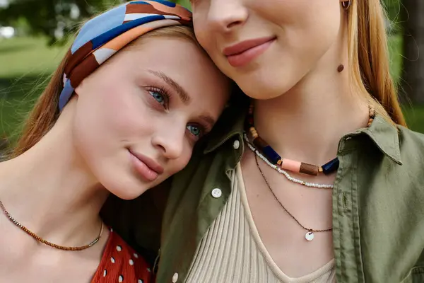 A young lesbian couple shares a tender moment in a green park, their love and connection shining through. — Stock Photo