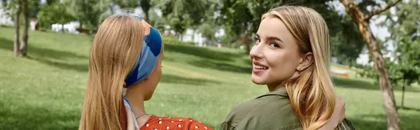 A young lesbian couple enjoys a sunny day in a green park, their love shining bright. — Stock Photo