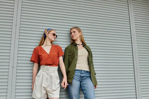 A young lesbian couple shares a tender moment while strolling through a city — Stock Photo