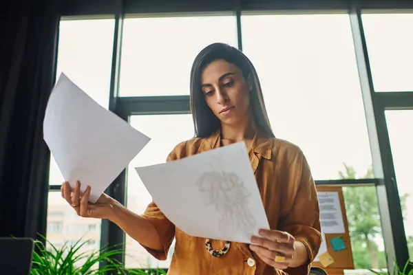 A beautiful Middle Eastern woman with brunette hair works in a bright office, reviewing documents. — Stock Photo