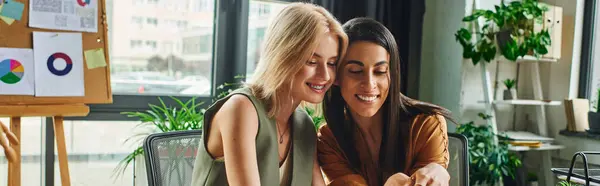 Deux femmes en tenue décontractée intelligente collaborent volontiers à un projet dans un cadre de bureau moderne — Photo de stock