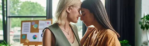Lesbian couple, dressed professionally, stand close to each other in a cozy workspace. — Stock Photo
