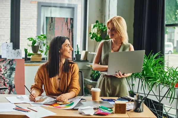 Two young women in a modern workspace, working on a project. — Stock Photo