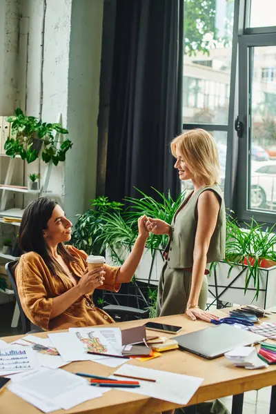 Couple lesbien, habillé en tenue décontractée intelligente, collaborer sur un projet dans un bureau d'agence moderne. — Stock Photo