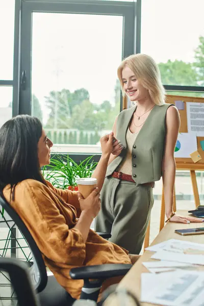 Lesbian couple, dressed in smart casual attire, work on a project in a modern, cozy workspace. — Stock Photo