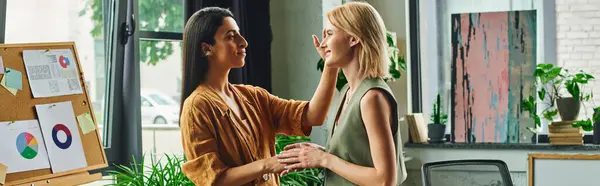 Two young women, dressed in smart casual attire, stand in a cozy workspace, focused on a project. — Stock Photo