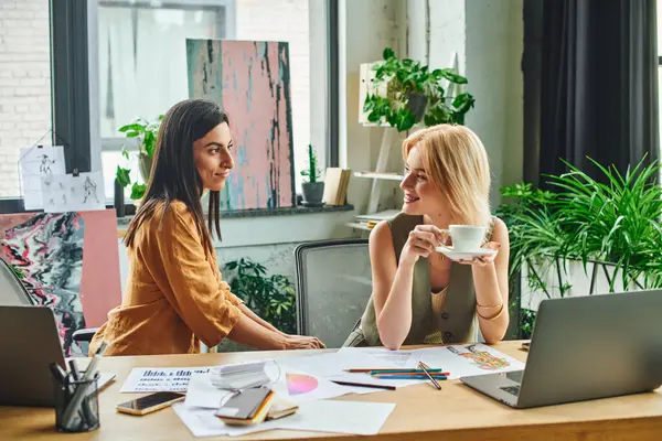 Two young women work on a project in a modern agency, lesbian couple — Stock Photo
