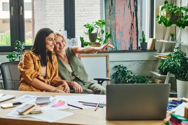 Two women in a modern office work together on a project, looking confident and professional — Stock Photo