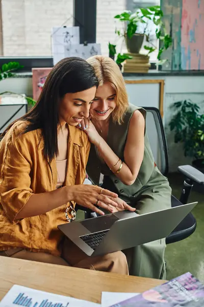 Two women in smart casual attire work on a project together in a cozy workspace. — Stock Photo