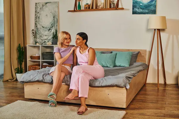 A lesbian couple cuddles on their bed, enjoying a quiet moment together. — Stock Photo